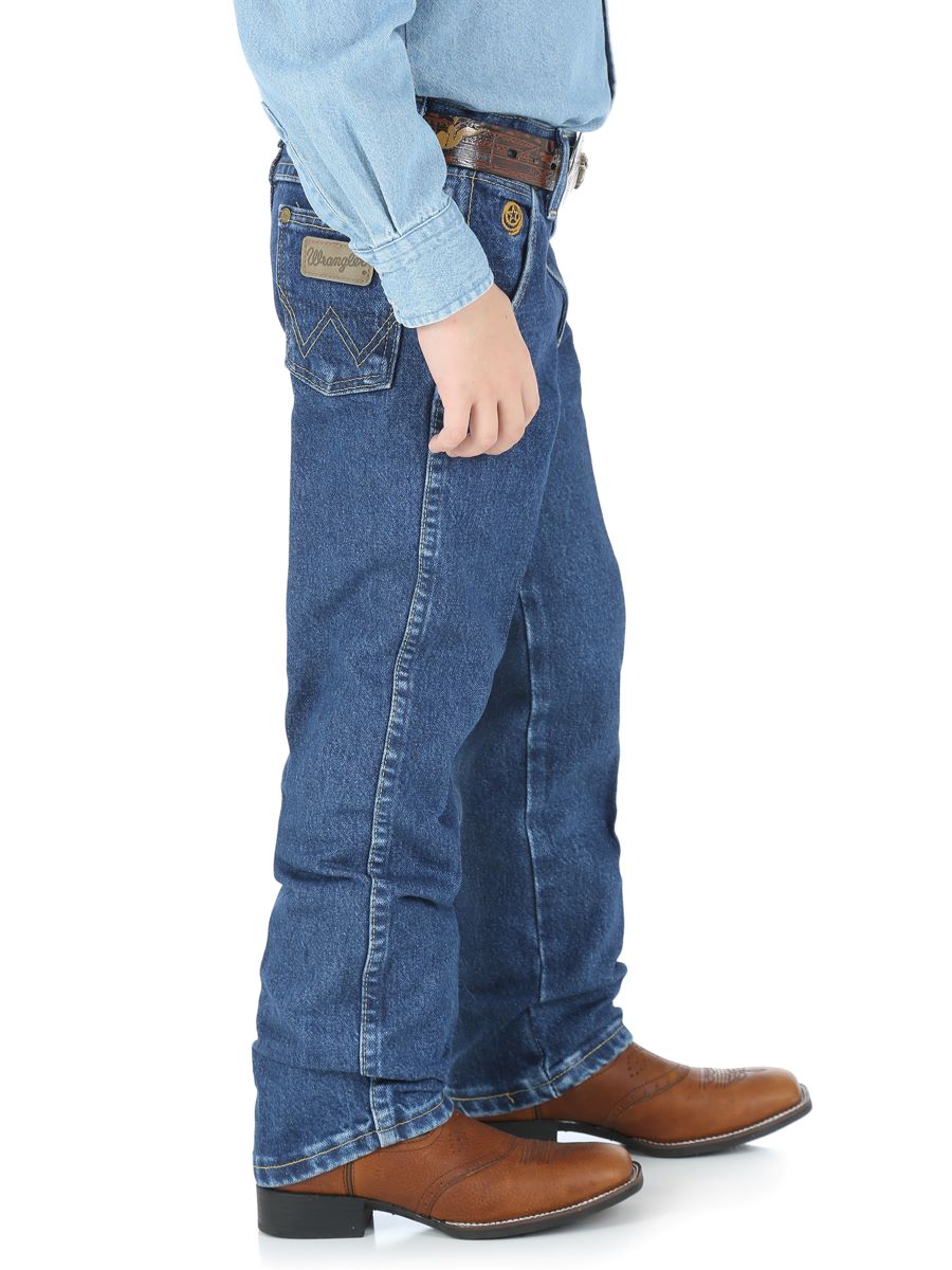 Boy wearing blue jeans and brown boots on a white background
