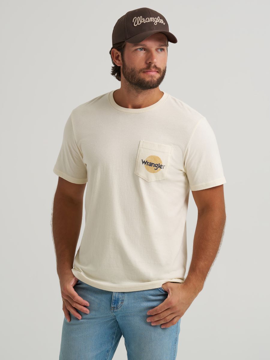Man wearing a beige t-shirt with a Wrangler logo and a brown cap on a light gray background