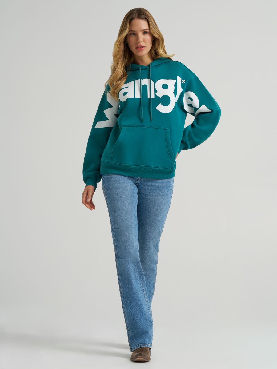 Woman wearing a teal hoodie with a 'Wrangler' logo on a plain background