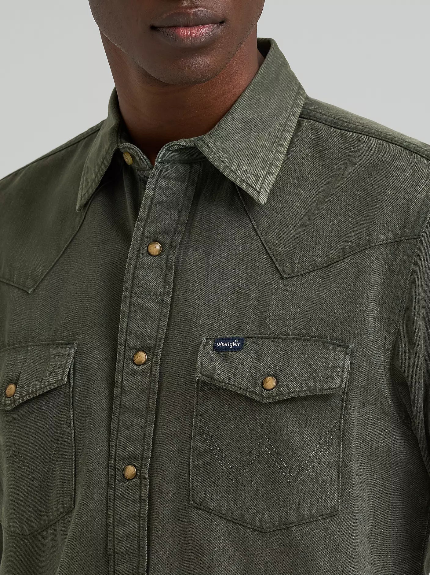 man wearing a green denim Wrangler shirt on a white background