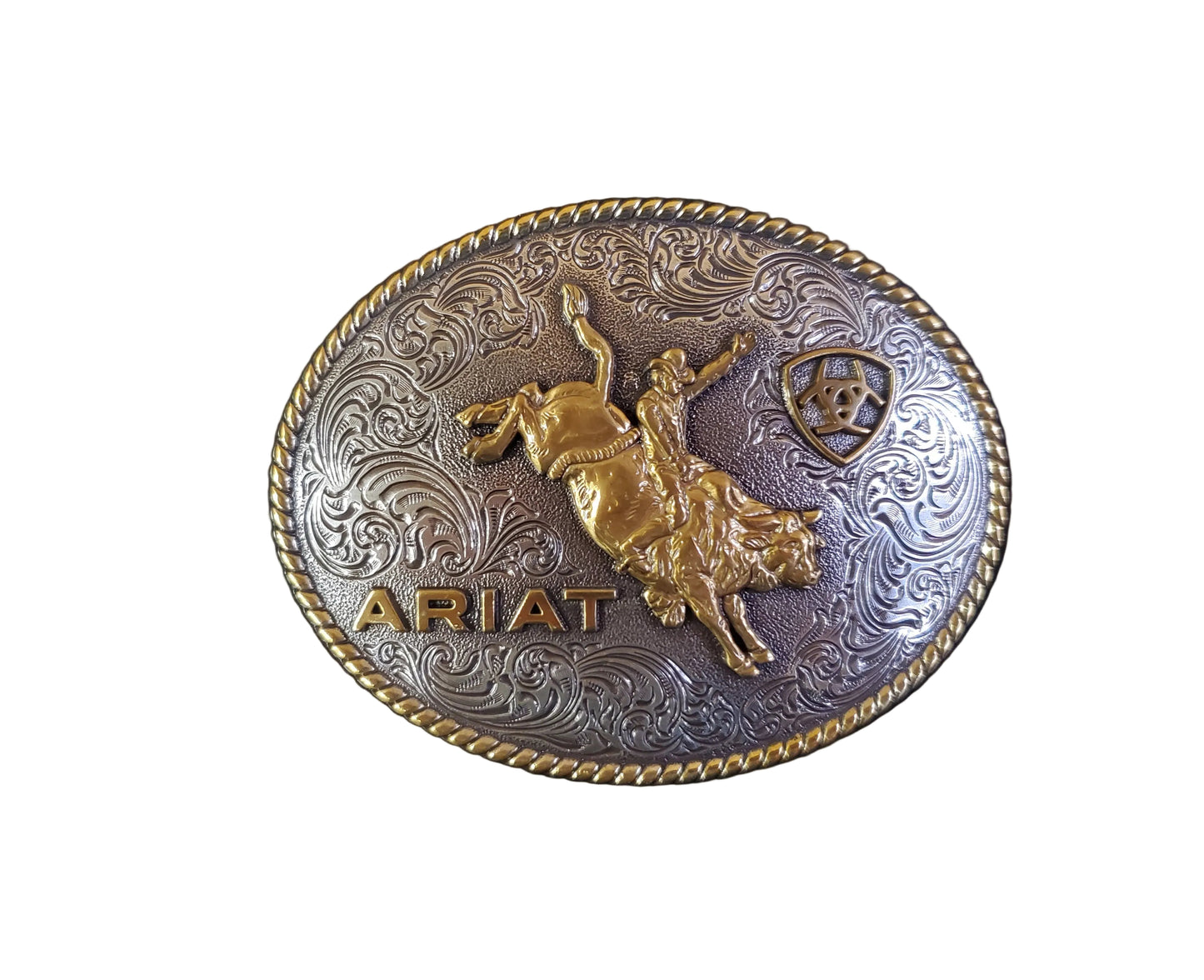 an oval rope edge gold and silver belt buckle with a bull rider and ARIAT on it
