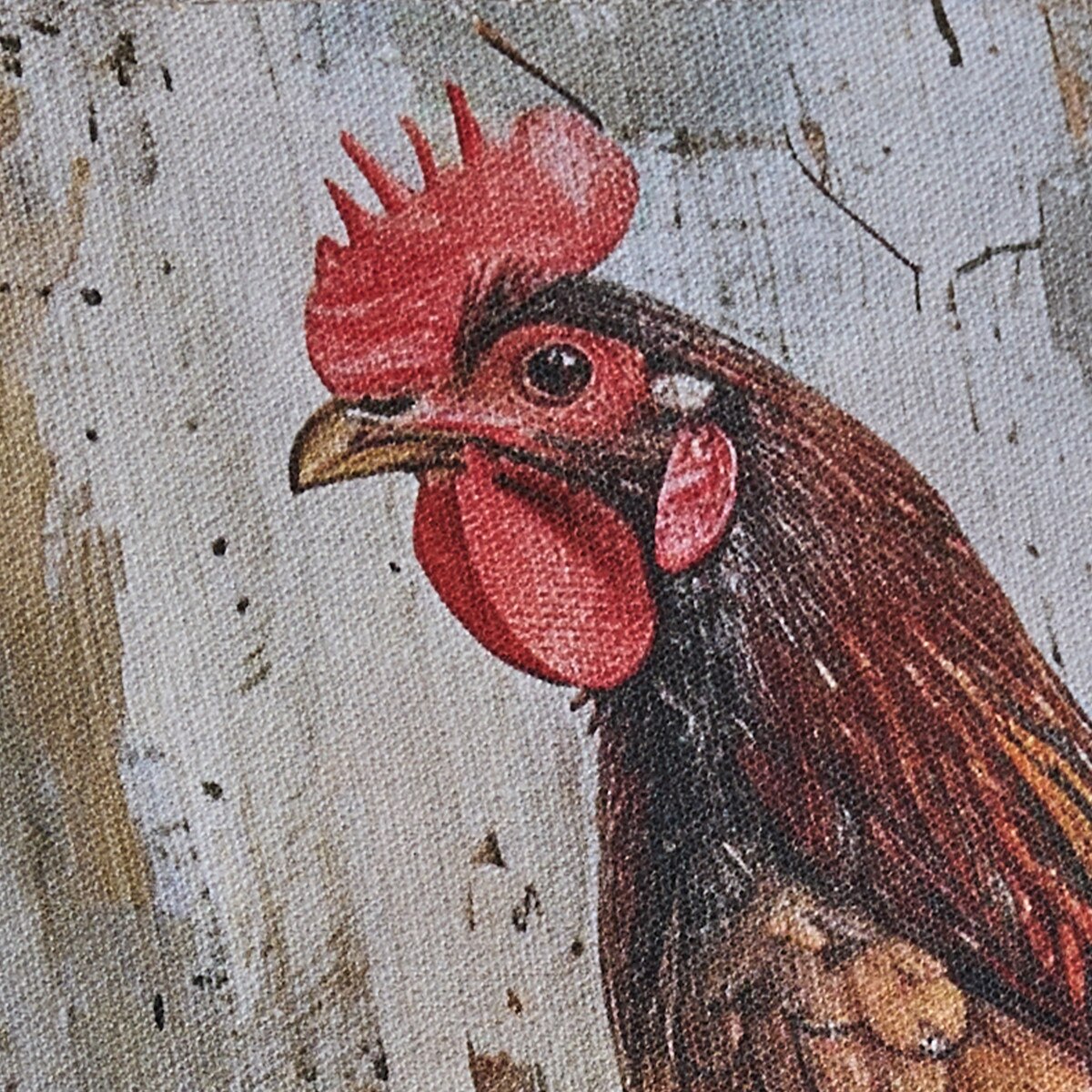 Close-up of a rooster illustration on a textured fabric background