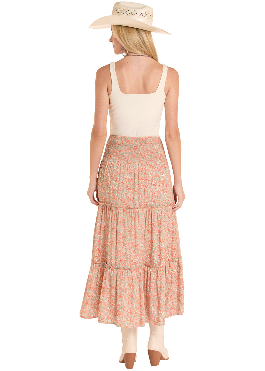 Woman wearing a white top and pink Rock&Roll Denim tiered skirt with a beige hat on a white background