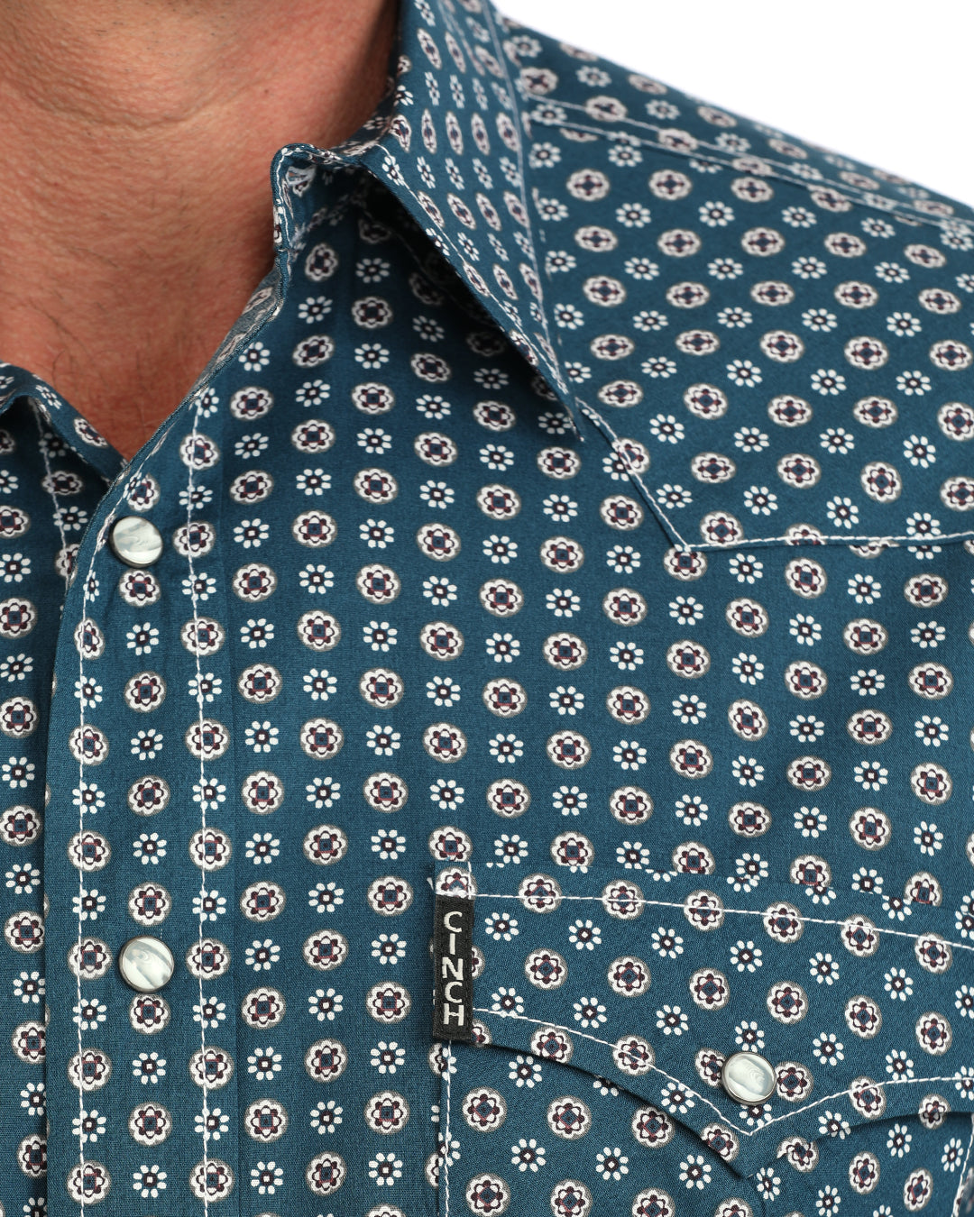 Close up of a man wearing a blue floral Cinch shirt on a white background