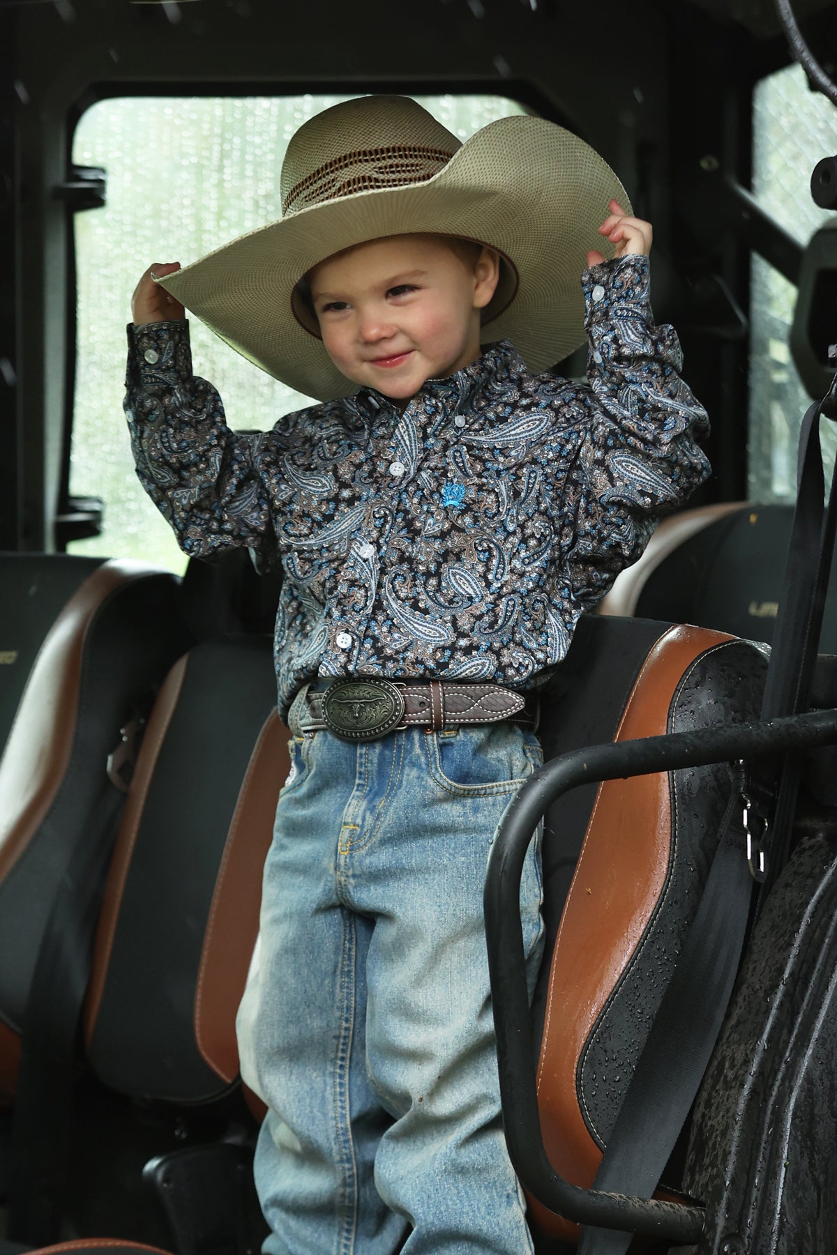 Boy wearing Cinch blue shirt with jeans and cowboy hat