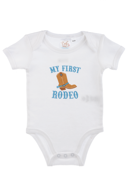 White Ganz baby onesie with 'My First Rodeo' text and cowboy boot graphic on a white background