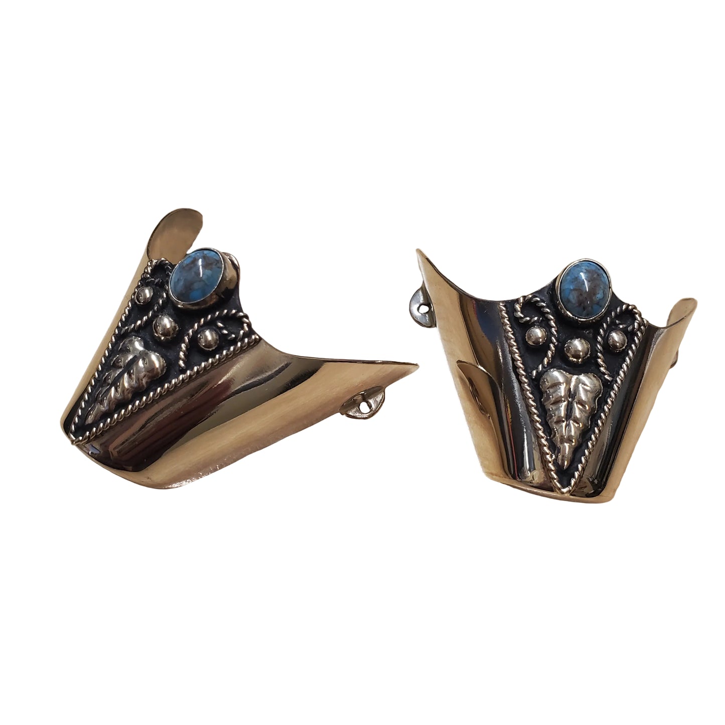 A pair of silver-toned metal cuff-style earrings with blue oval stones and ornate engraved details
