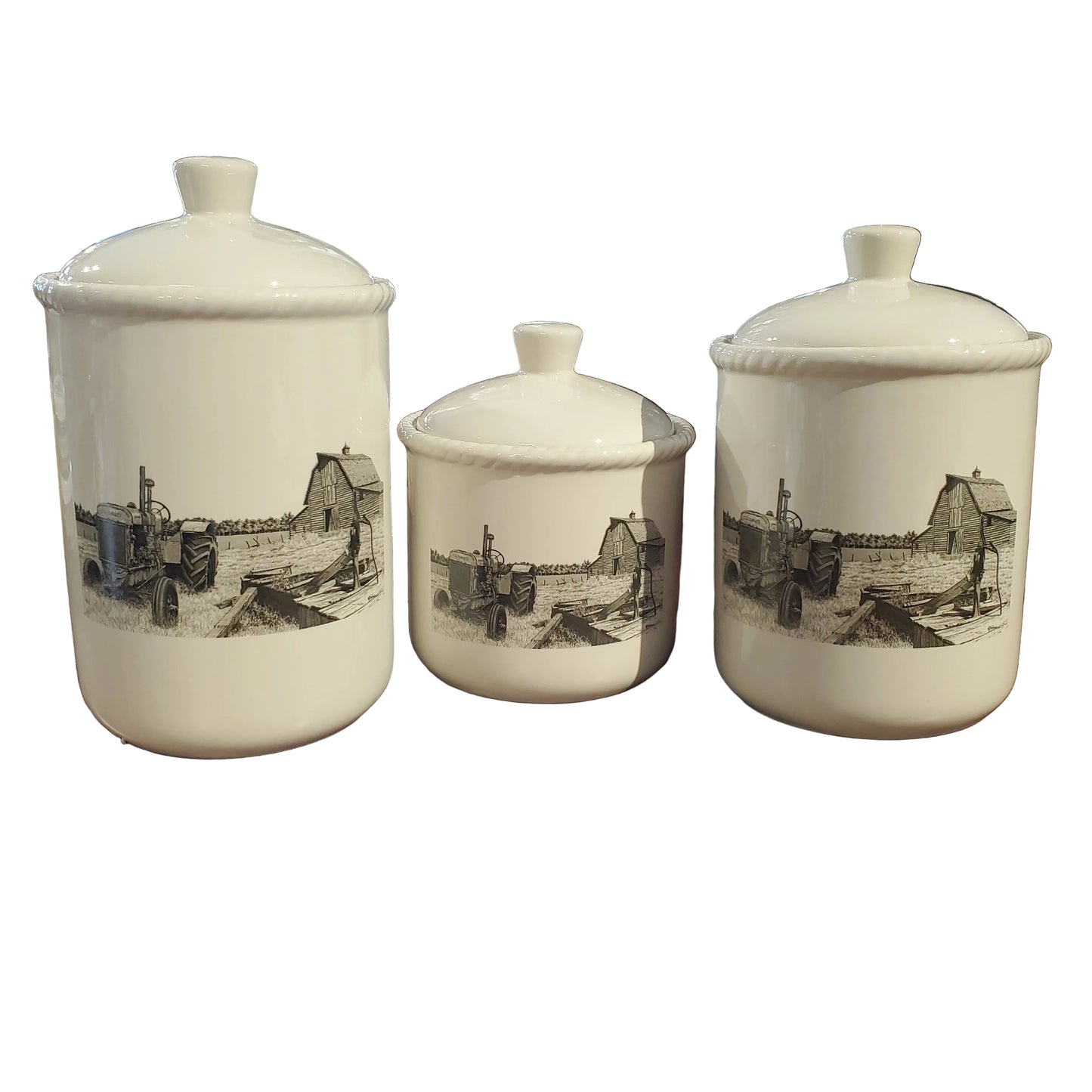 Three white ceramic jars with black illustrations of an old run down farmstead