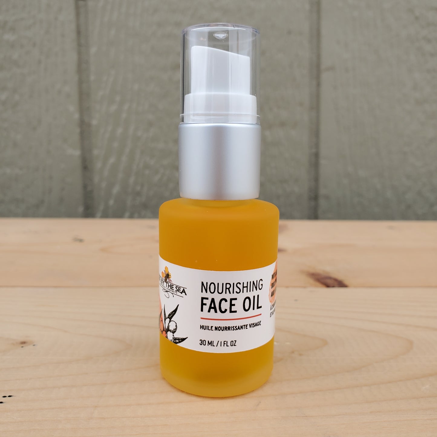 Bottle of nourishing face oil on a wooden surface with a neutral background