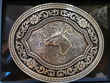 Buckle with horse head an floral detail on a black background