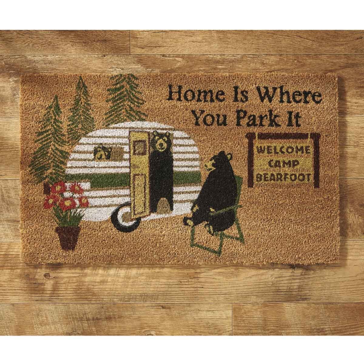 Doormat with camper and bear design on a wooden floor