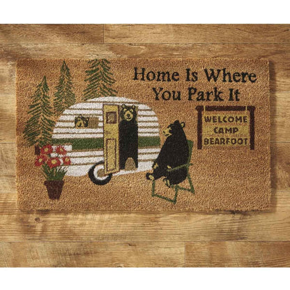 Doormat with camper and bear design on a wooden floor