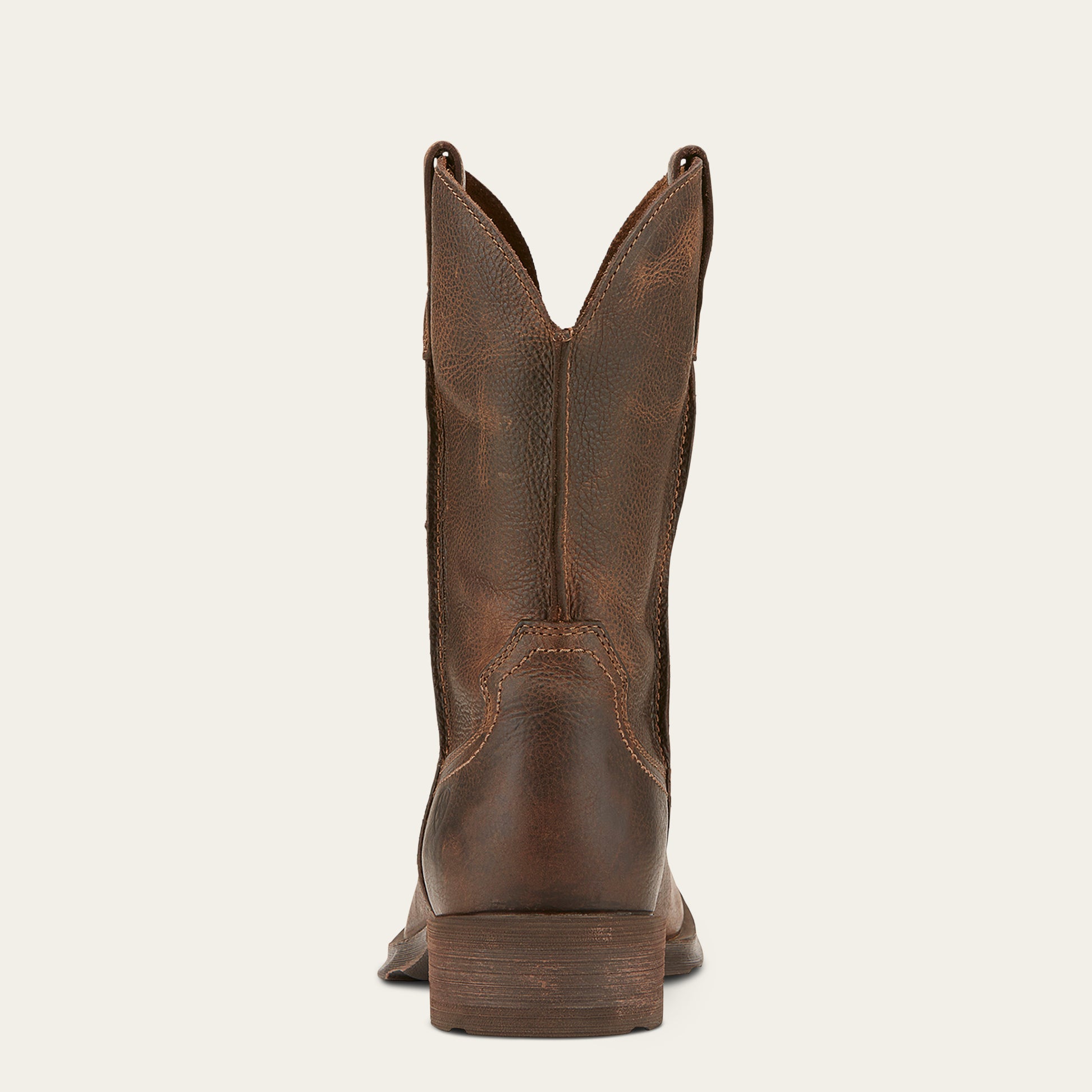 the back of a distressed brown men's cowboy boot on a cream colored background