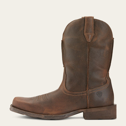 a distressed brown cowboy boot with a boxy square toe on an off white background