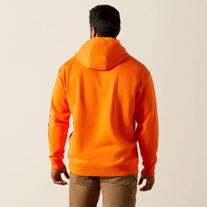Person wearing an orange Ariat hoodie from behind on a beige background