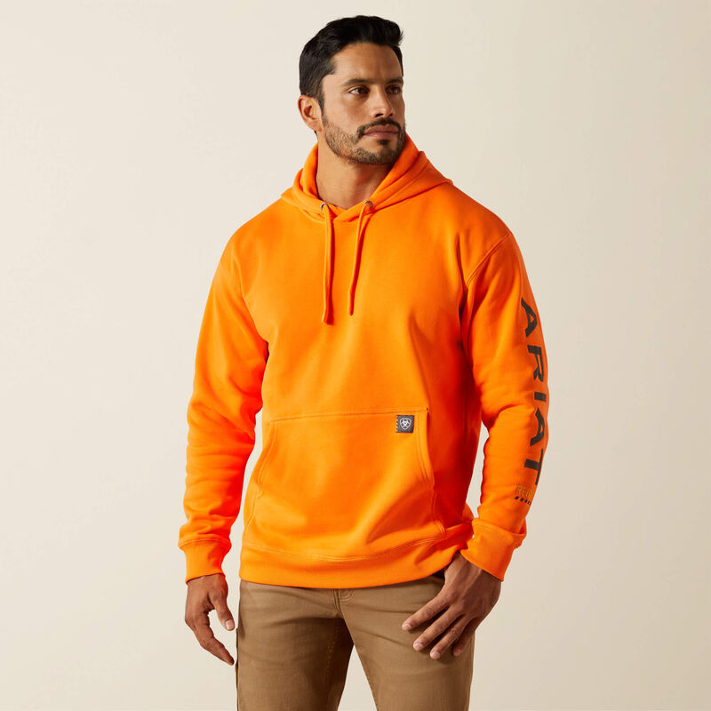 Man wearing an orange Ariat hoodie with a brand logo on a beige background