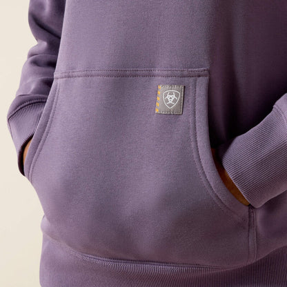 Close-up of a purple Ariat hoodie with a logo on the chest pocket against a beige background