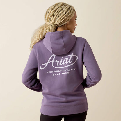 Person wearing a purple Ariat hoodie on a beige background
