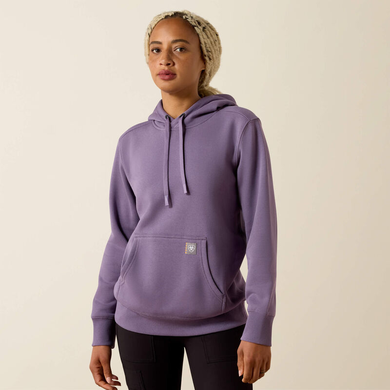 Person wearing a purple Ariat hoodie on a beige background