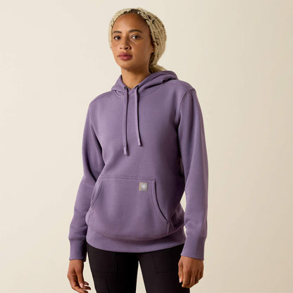 Person wearing a purple Ariat hoodie on a beige background