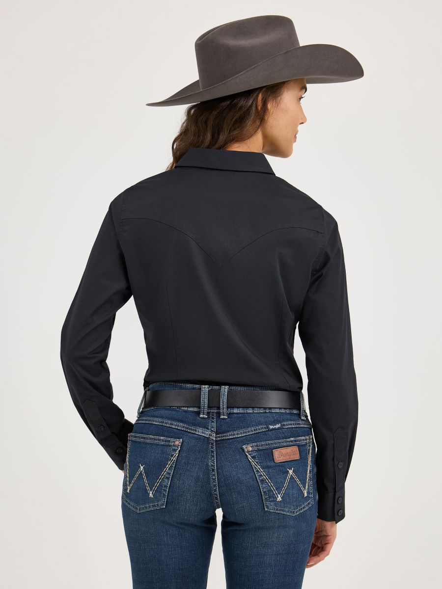 Woman wearing a black Wrangler shirt, blue jeans, and a gray cowboy hat on a white background