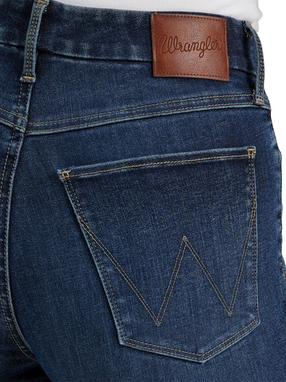 Close-up of blue jeans with a brown leather patch and 'Wrangler' branding.