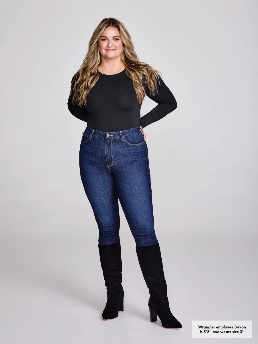 Woman wearing blue jeans and black knee-high boots on a white background