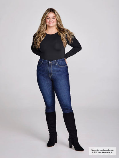 Woman wearing blue jeans and black knee-high boots on a white background
