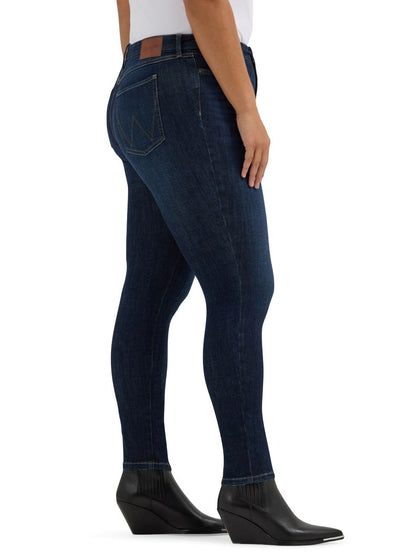 Dark blue jeans worn by a person on a white background
