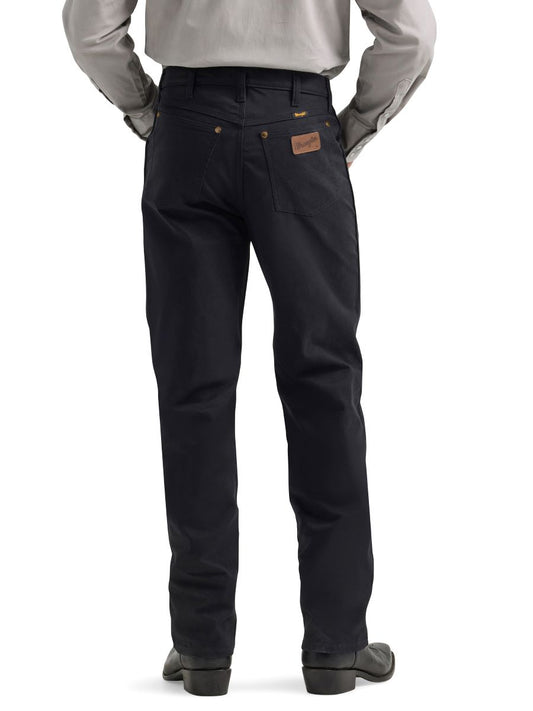 Person wearing black pants with a leather wrangler patch on a white background