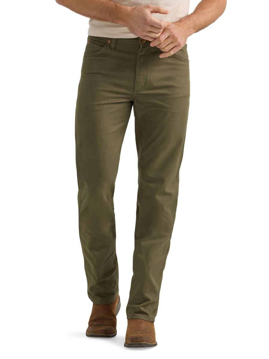 A man wearing a pair of olive green Wrangler cowboy cut canvas jeans and brown boots.