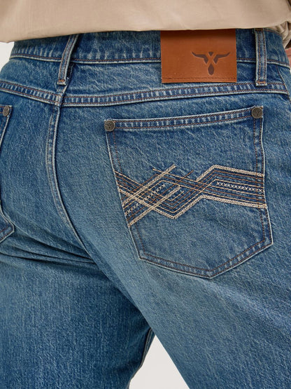 Close-up of blue Wrangler jeans with a brand logo on the back pocket.