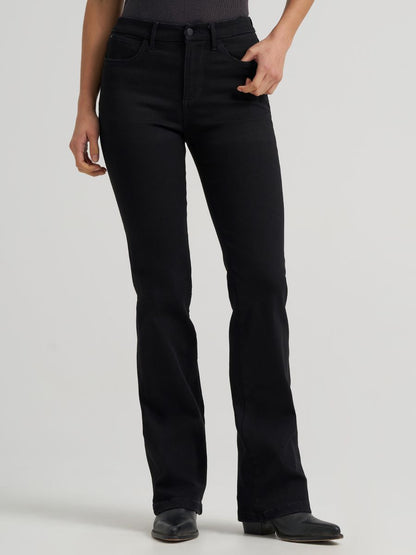 a front view of a woman wearing black jeans and cowboy boots on a grey background