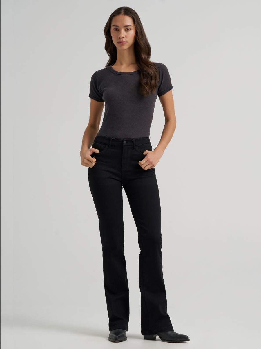 a woman wearing black jeans and a grey t shirt on a grey background
