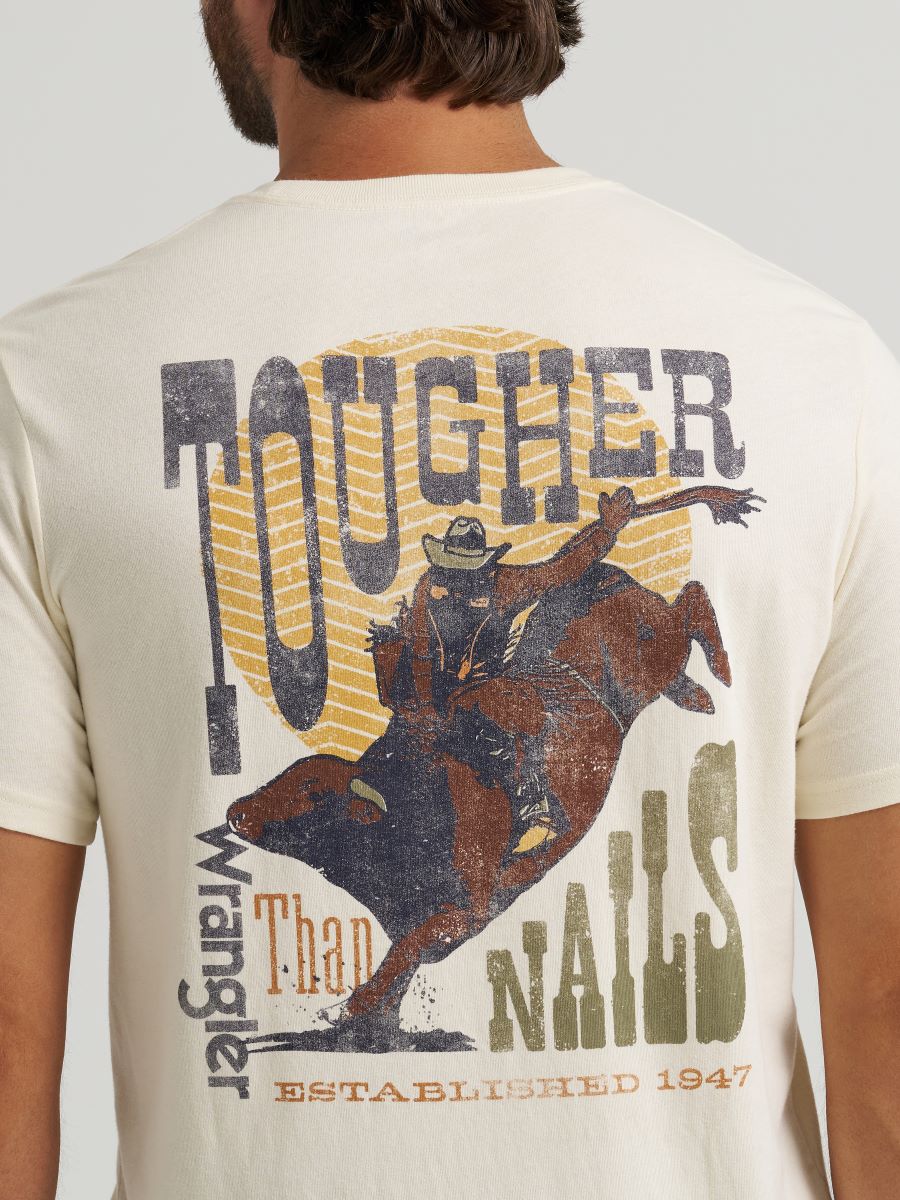 Beige t-shirt with a graphic of a cowboy on a horse and text on the back, worn by a person.