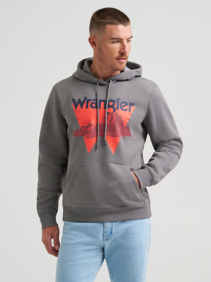 Man wearing a gray 'Wrangler' hoodie with a red and blue logo on a light gray background