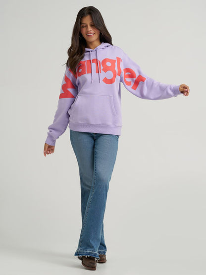 Person wearing a light purple hoodie with red text and blue jeans on a gray background