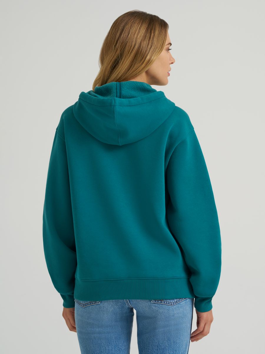 Person wearing a teal hoodie on a plain background