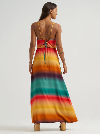 Woman wearing a colorful striped maxi dress on a white background