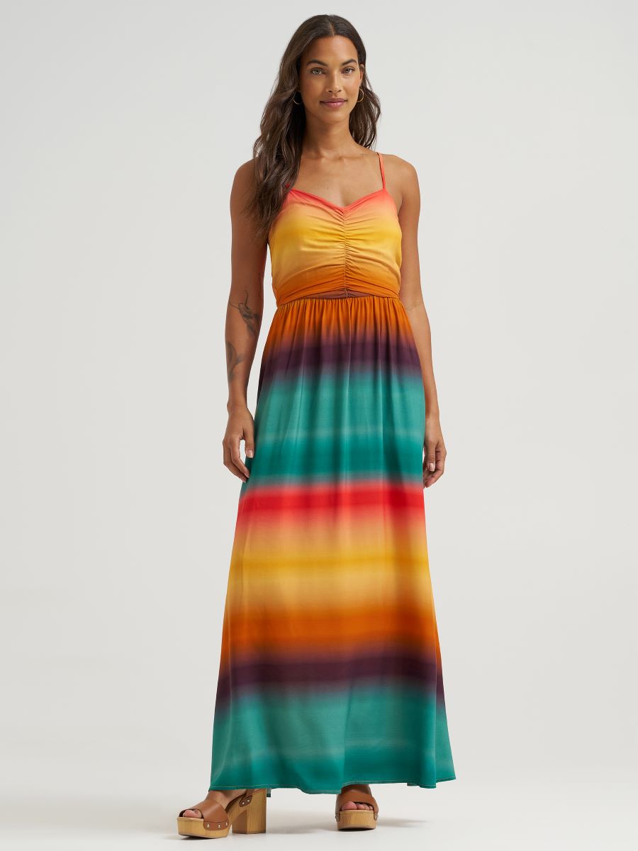 Woman wearing a colorful striped maxi dress on a white background