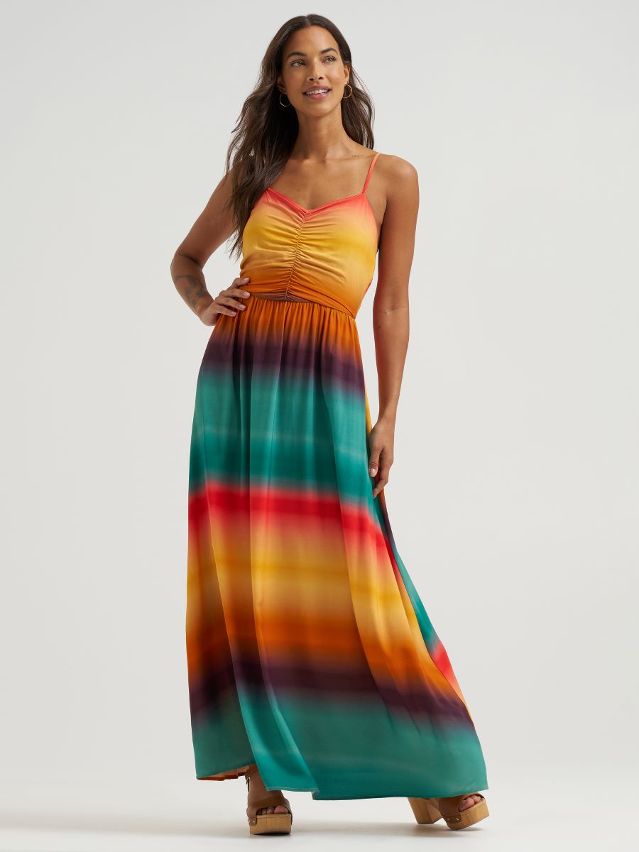 Woman wearing a colorful striped maxi dress on a white background