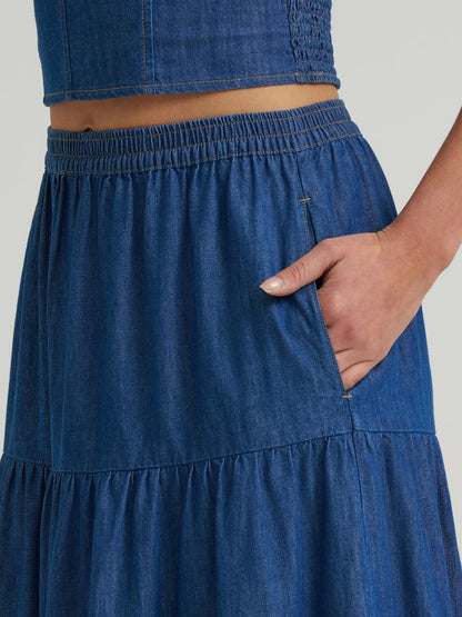Blue denim skirt worn by a person on a plain background