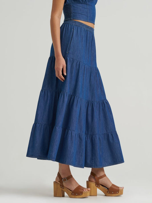 Blue tiered denim skirt worn by a person on a plain background