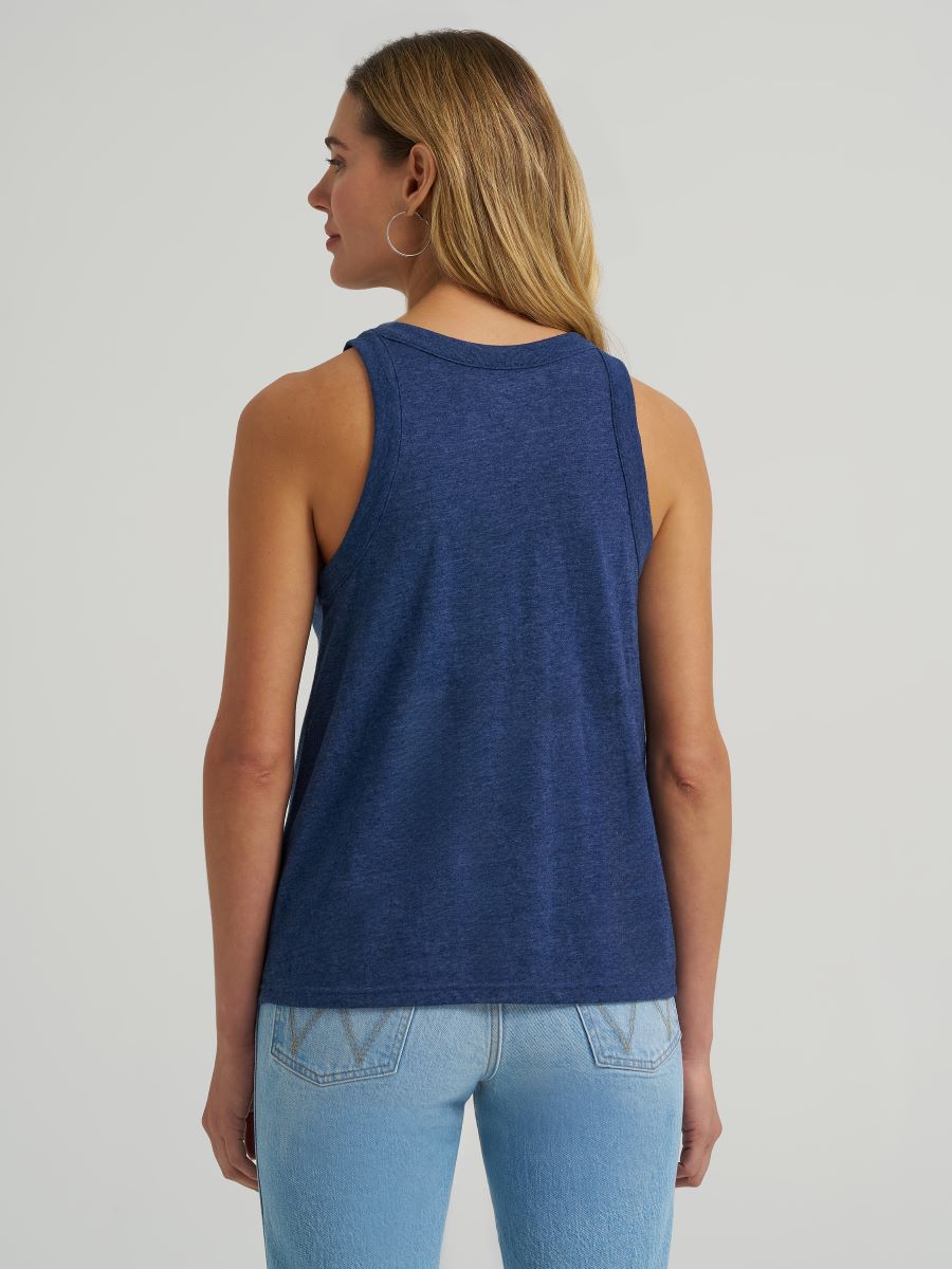 Woman wearing a blue Wrangler tank top and jeans on a plain background