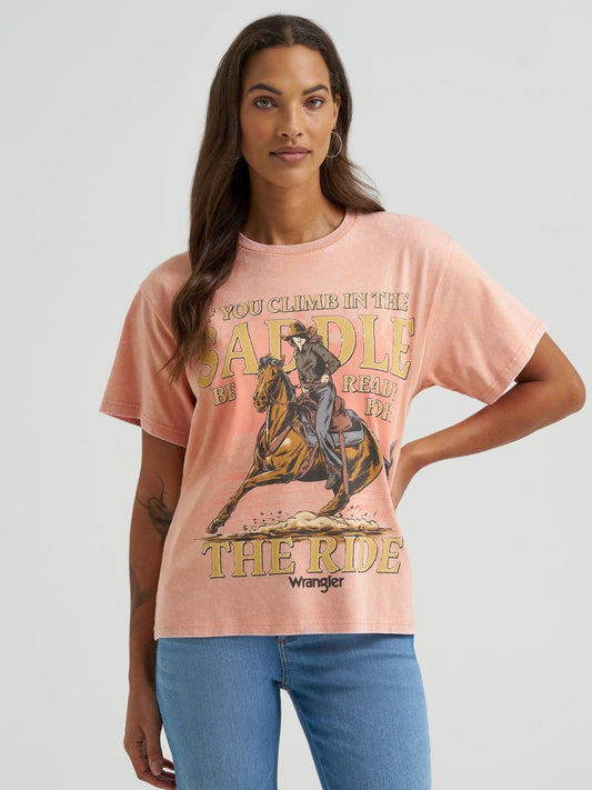 Woman wearing a pink Wrangler t-shirt with a graphic design on a light gray background