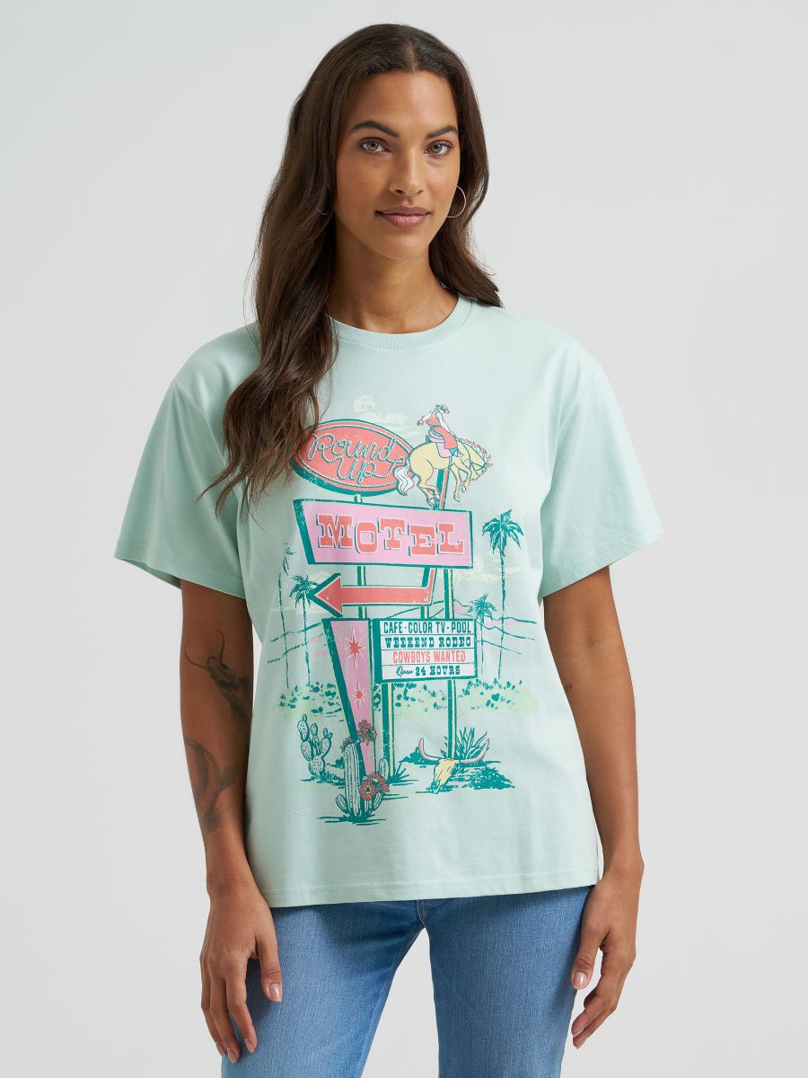 Woman wearing a green Wrangler t-shirt with a colorful graphic design on a white background