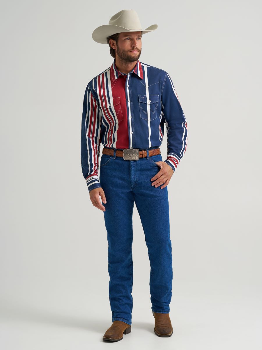 Man wearing a colorful striped Wrangler shirt, blue jeans, and a cowboy hat on a gray background