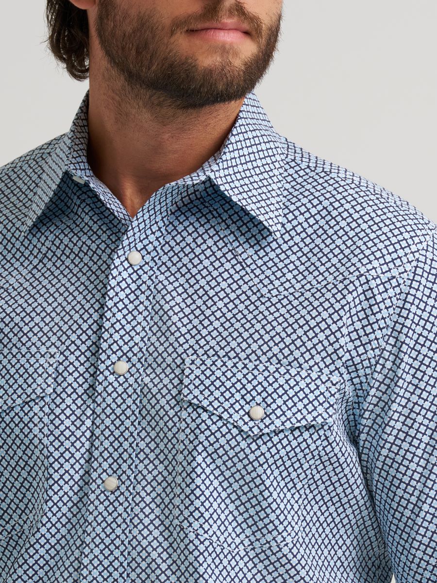 Man wearing a blue patterned Wrangler shirt with a neutral background