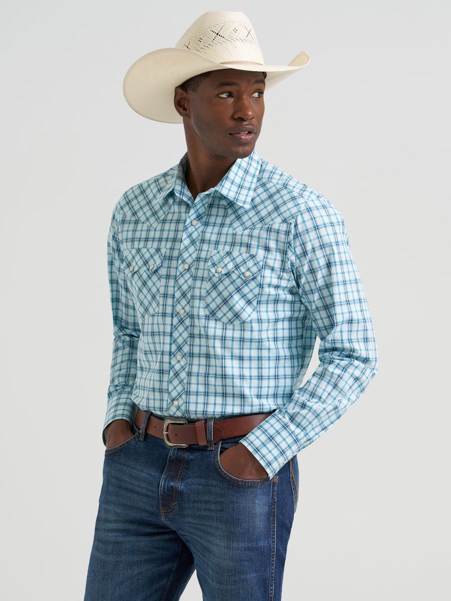 Man wearing a blue plaid Wrangler shirt, jeans, and a cowboy hat on a light gray background