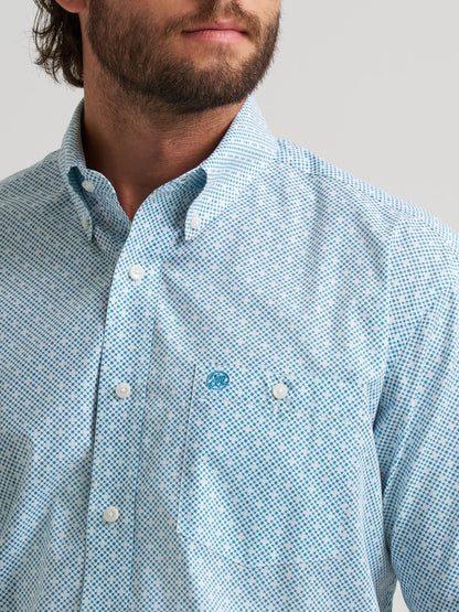 Close-up of a person wearing a light blue checkered Wrangler shirt with a brand logo on a gray background